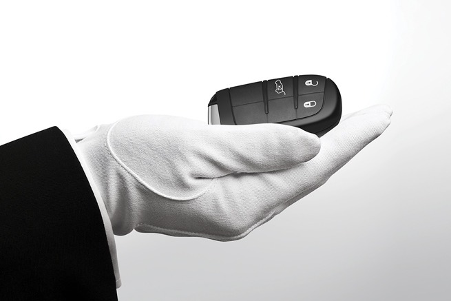 Une main gantée présente une clé de voiture noire
