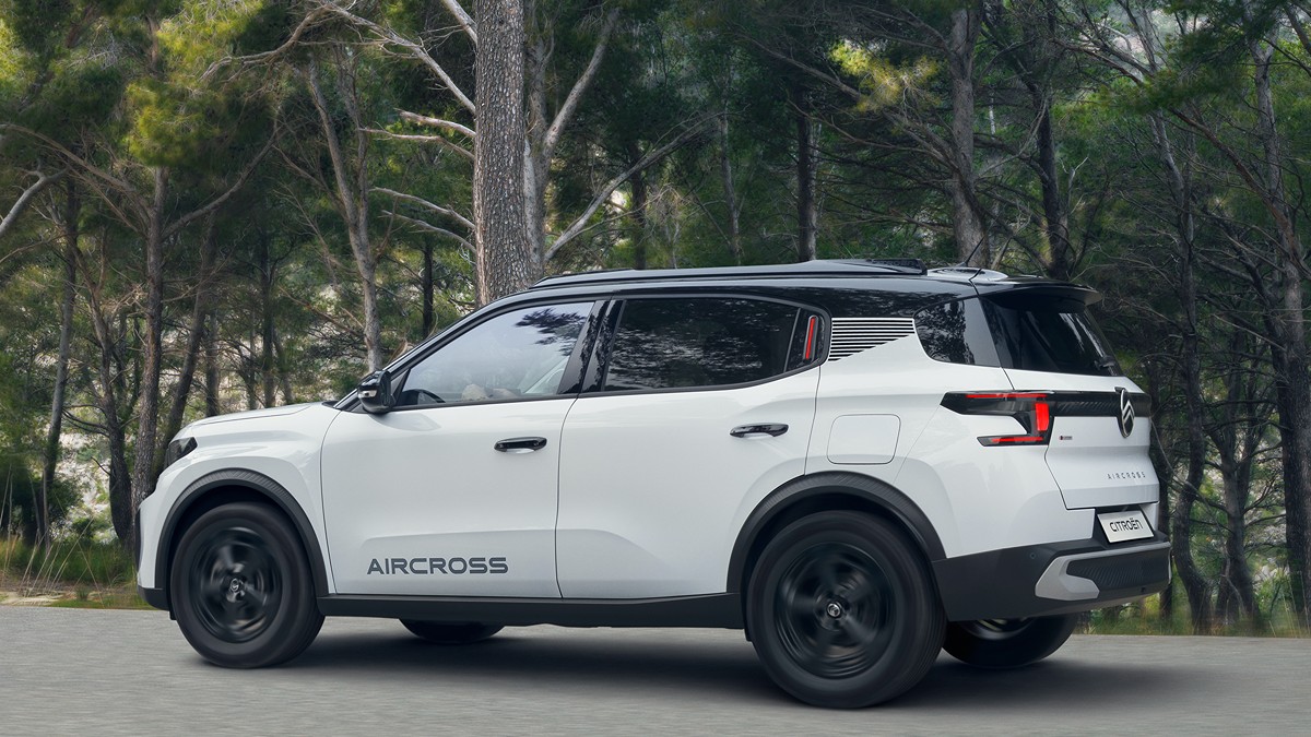 Voiture Citroën eC3 blanche roulant dans une forêt de pins